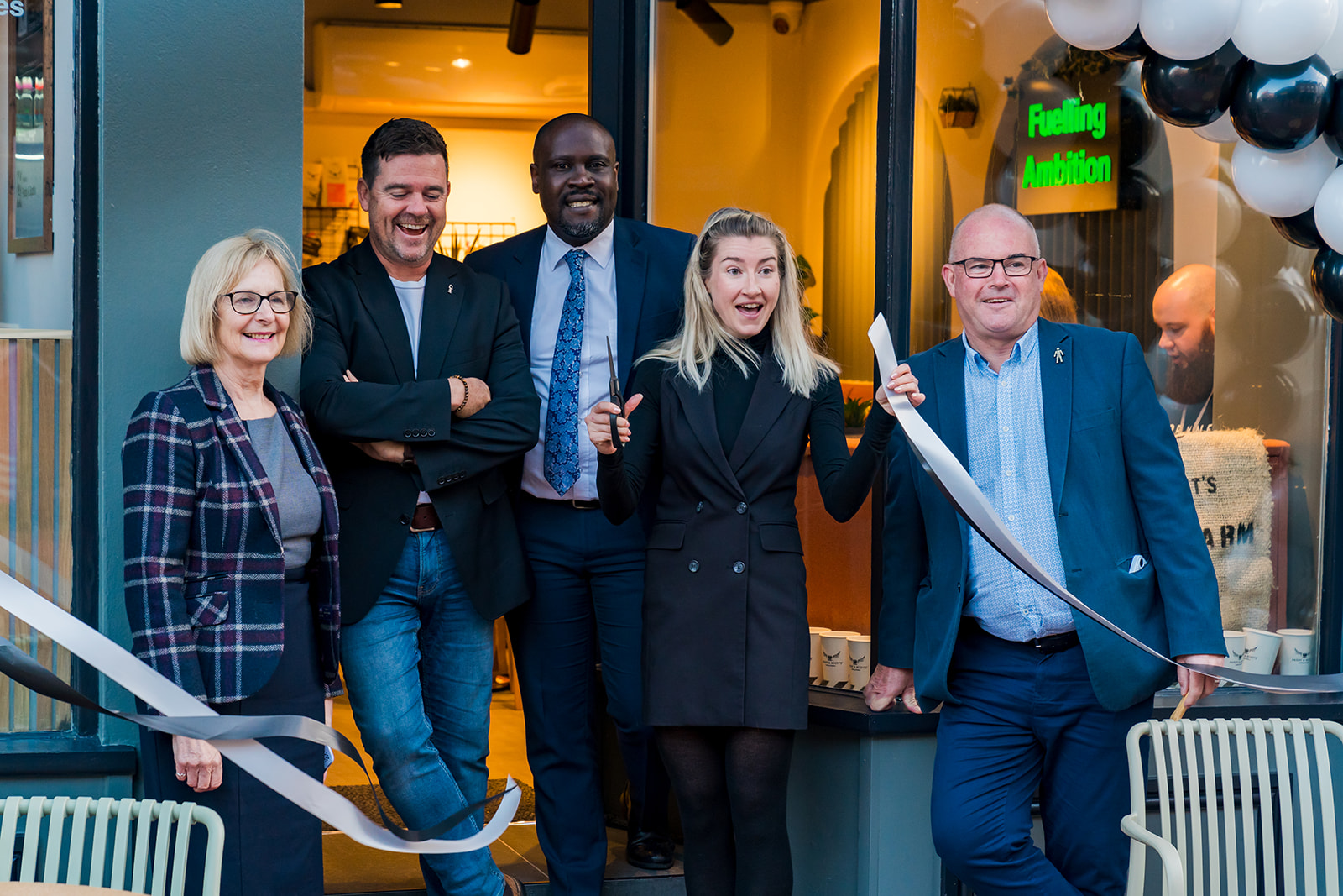 Guests cutting a ribbon at the opening of Paddy & Scott's coffee shop in Lichfield.