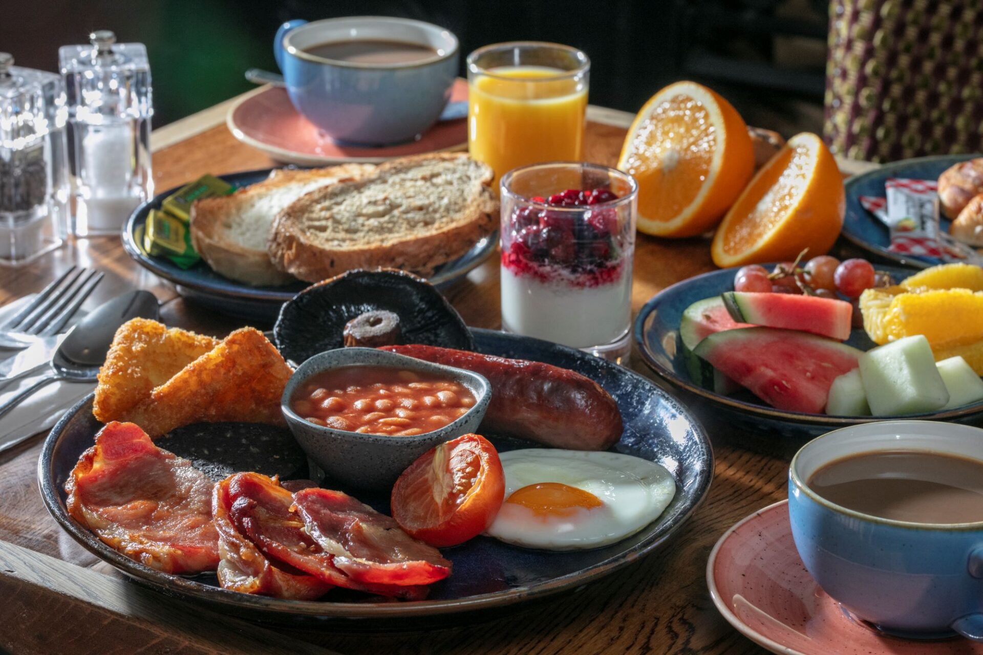 Cooked breakfast with toast, fruit, yoghurt, juice and hot drinks