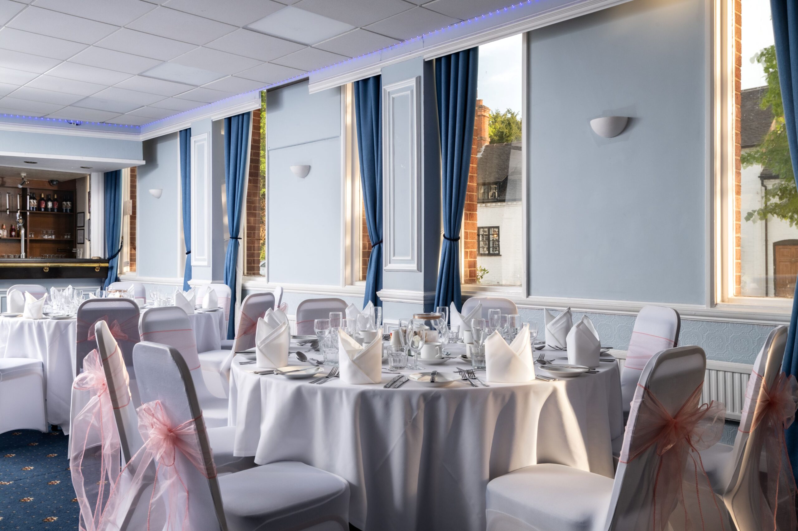 Wedding reception tables with flowers and covered chairs